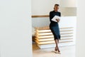 Stern elegant business woman wearing black dress and beige shoes in light office looking at her agenda, full length portrait Royalty Free Stock Photo