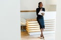 Stern elegant business woman wearing black dress and beige shoes in light office looking towards with her agenda, full length port Royalty Free Stock Photo