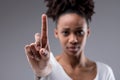 Stern focused young woman holding up her index finger Royalty Free Stock Photo