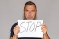 Stern middle-aged man holding a Stop sign