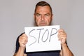 Stern middle-aged man holding a Stop sign