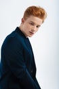 Stern red-haired young man thinking