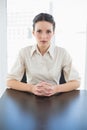 Stern stylish brunette businesswoman posing looking at camera