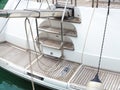 Stern of the yacht with a ladder. Fragment of a ship moored in the bay. Closeup photo Royalty Free Stock Photo