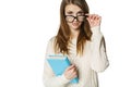 Stern young woman looking over top of eyeglasses