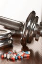 Steroid pills with dumbbell waight in the background - doping in Royalty Free Stock Photo