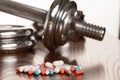 Steroid pills with dumbbell waight in the background - doping in Royalty Free Stock Photo