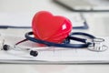 Stethescope and red heart lying on cardiogram Royalty Free Stock Photo