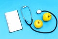 Stethoscope, apple fruit and notebook ,cardiogram on table. Cardiology concept Royalty Free Stock Photo