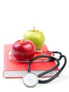 Stethoscope and apples on a book Royalty Free Stock Photo