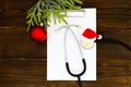 Stethoscope, blank clipboard and Christmas decorations on wooden white table