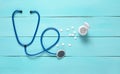 Stethoscope and bottle with pills on a blue wooden background, medical concept, top view. Royalty Free Stock Photo