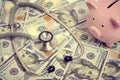 Stethoscope, bunch dollars and piggy bank, concept expensive medicine Royalty Free Stock Photo