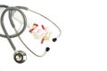 Stethoscope and bunch pills on white background