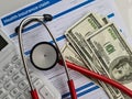 Stethoscope calculator dollars and medical insurance closeup