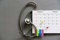 Stethoscope and calendar on the gray background, schedule to check up healthy concept