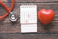 stethoscope, calendar and heart shape symbol on table