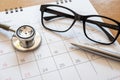 Stethoscope and calendar on wooden table, schedule to check up healthy concept Royalty Free Stock Photo