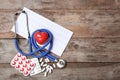 Stethoscope, cardiogram and pills on wooden background. Cardiology service