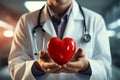 A stethoscope clad doctor cradles a red heart symbol in a hospital environment