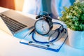 Stethoscope, clipboard, clock and laptop on doctor desk Royalty Free Stock Photo