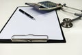 Stethoscope with clipboard on desk,Doctor working in hospital writing a prescription Royalty Free Stock Photo