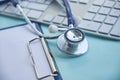 Stethoscope with clipboard and Laptop on desk,Doctor working in hospital writing a prescription. Healthcare and medical Royalty Free Stock Photo