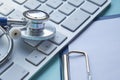 Stethoscope with clipboard and Laptop on desk,Doctor working in hospital writing a prescription. Healthcare and medical Royalty Free Stock Photo