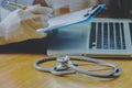 Stethoscope with clipboard and Laptop on desk,Doctor working in Royalty Free Stock Photo