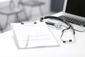 Stethoscope, clipboard with medical form lying on hospital reception desk with laptop computer. Medical tools at doctor Royalty Free Stock Photo