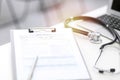 Stethoscope, clipboard with medical form lying on hospital reception desk with laptop computer. Medical tools at doctor Royalty Free Stock Photo