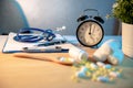 Stethoscope, clipboard and table clock on doctor desk