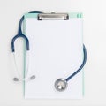 Stethoscope and clipboard on white background. Medical inspection concept.