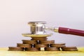 Stethoscope with coins stack on white background. medical cost rising.