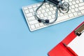 Stethoscope on computer keyboard on blue background. Royalty Free Stock Photo