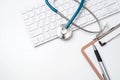 Stethoscope on computer keyboard on white background. Physician write medical case long term care treatment concept, top view, Royalty Free Stock Photo