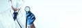 Stethoscope doctor medical background. Happy nurse in hospital uniform, blue gloves holding stethoscope isolated on Royalty Free Stock Photo