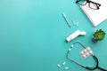 Stethoscope in doctors desk with keyboard, syringe, ampoules, inhaler and pills