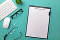 Stethoscope in doctors desk with tablet, pen, keyboard, mouse and pills