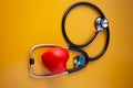 Stethoscope doctors and red heart cardiology placed on a Yellow table in the hospital, concept: diagnostics disease health prescr