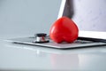 Stethoscope doctors and red heart placed on a white desk with laptop background hospital, concept: diagnostics disease health pr