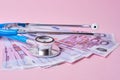 stethoscope and euro banknotes on pink background, a symbol of stability, growth and fall of currencies, monitoring the exchange Royalty Free Stock Photo