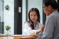 Stethoscope exam. Attractive cheerful asian female doctor listening to the elderly while using stethoscope