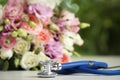 Stethoscope and flowers on white table against blurred background. World health day Royalty Free Stock Photo