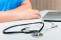 Stethoscope in focus, hands out of focus doctor