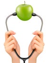 Stethoscope and a green apple. Medical background.