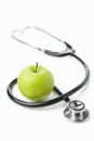 Stethoscope and green apple over white Royalty Free Stock Photo