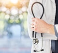 Stethoscope in hand, health and doctor with medical person, cardiology and surgeon in hospital with mockup space. Bokeh