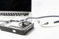 Stethoscope and hard disk drive on white background. Computer hardware diagnostic and repair concept Royalty Free Stock Photo