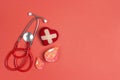 Stethoscope with heart and blood drop symbol on a red background with copy space Royalty Free Stock Photo